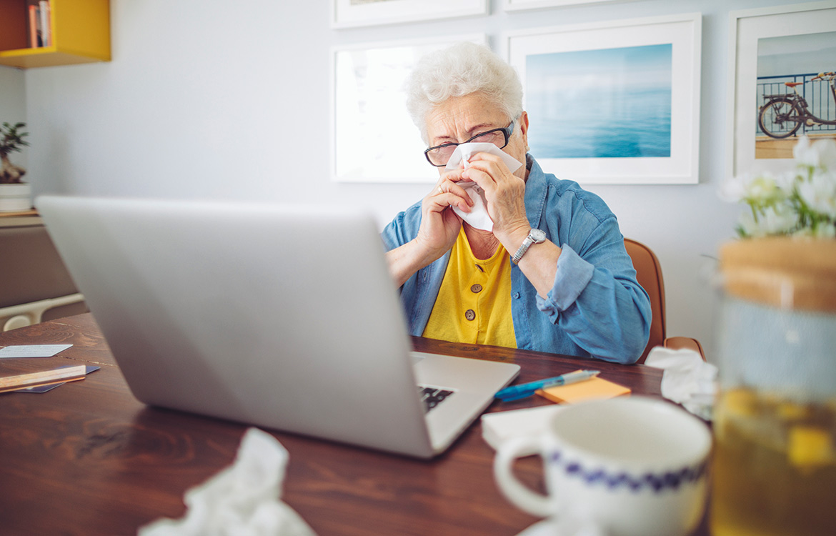 person blowing their nose with tissue